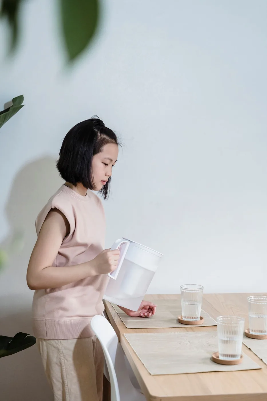 Child practising water pouring and table-care skills